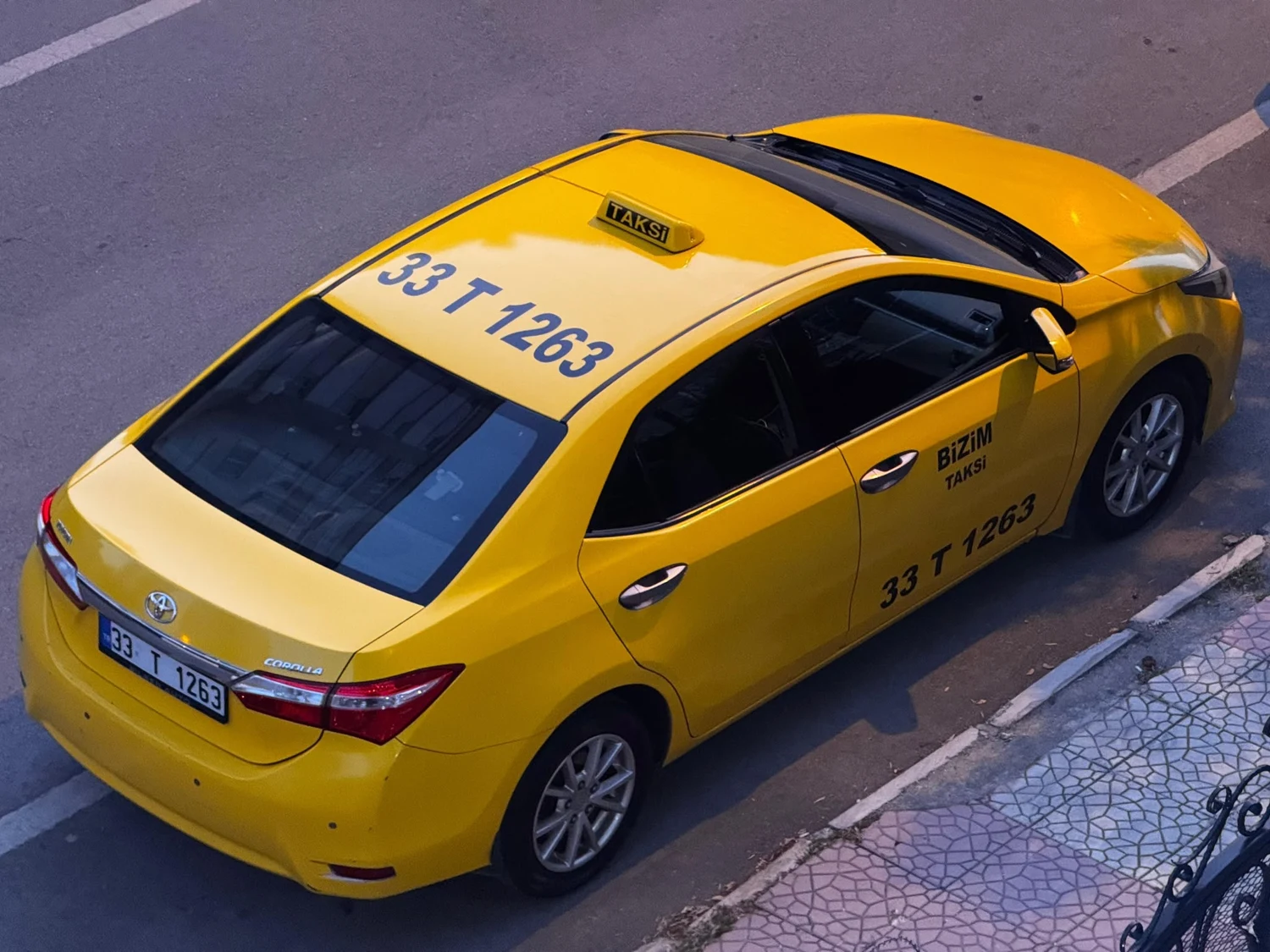 Sarı Toyota taksinin üstten görünümü